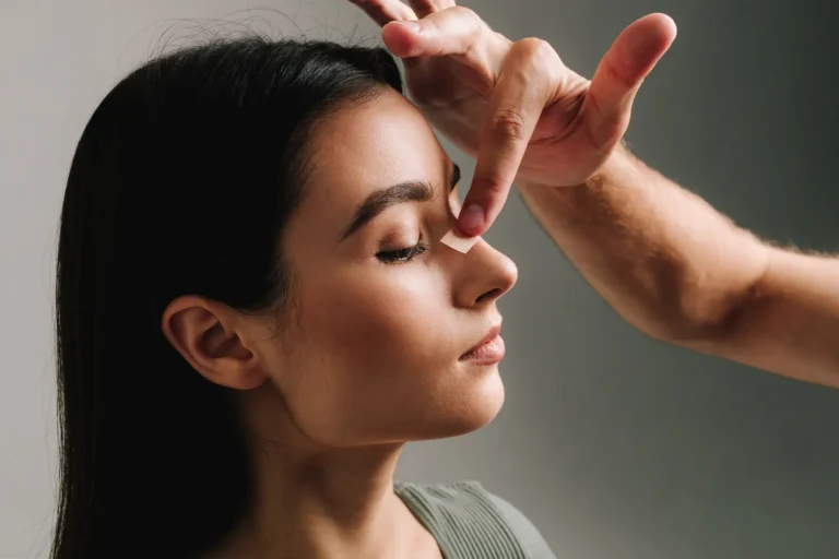 Doctor applying nasal taping during rhinoplasty recovery