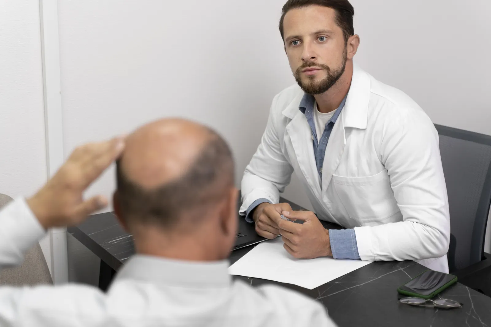 Man with hair loss in consultation with a hair transplant specialist