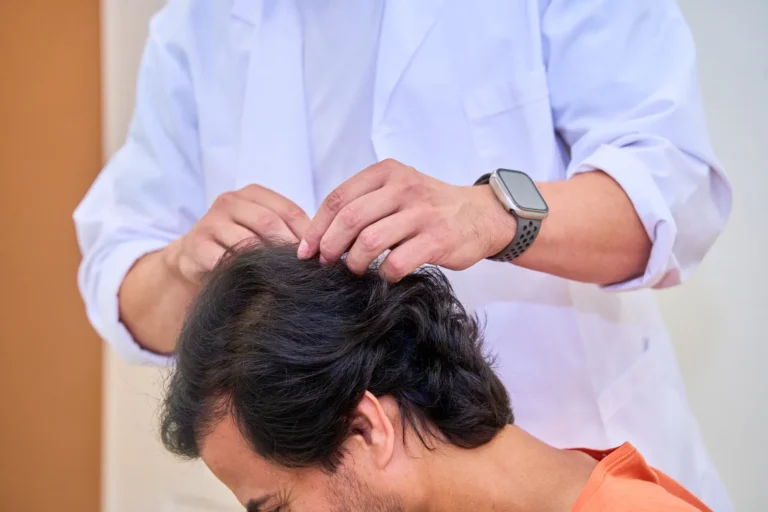 Doctor examining a patient's scalp to choose the hair transplant technique