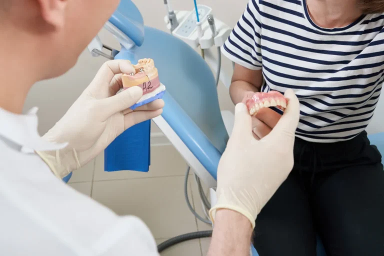 Dentist showing a patient a dental implant model in the clinic