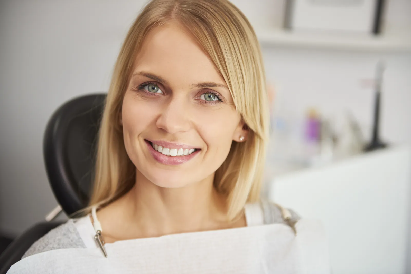 Smiling, relaxed patient sitting in a dental clinic chair