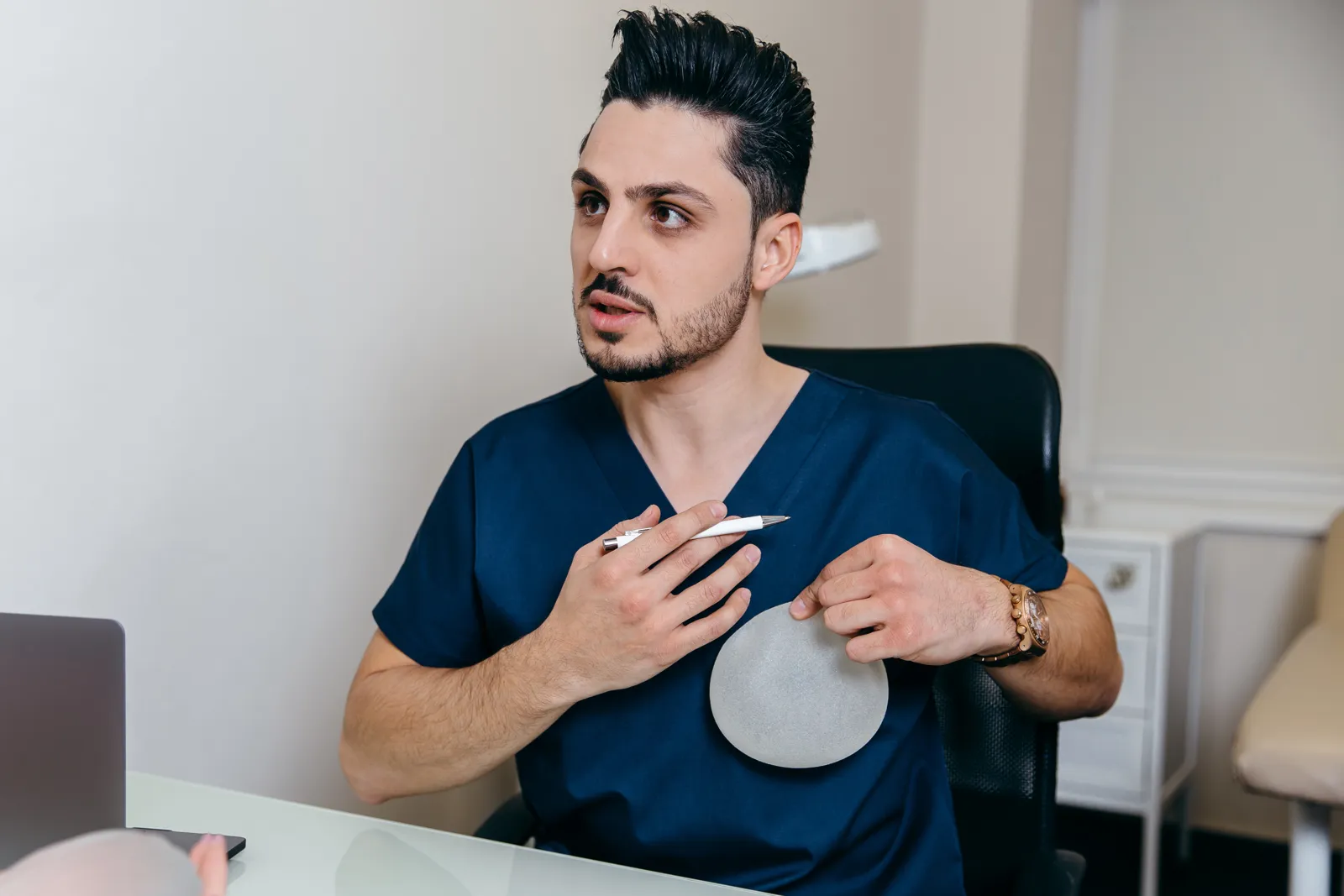Plastic surgeon explaining breast implant options during a consultation