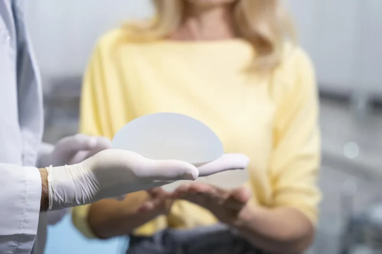 Doctor showing a silicone breast implant to a patient in consultation