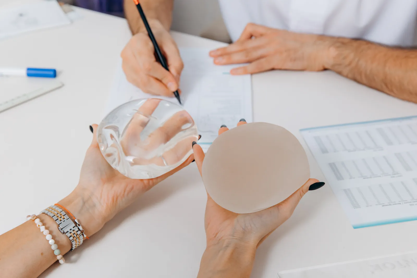 Patient compares two silicone breast implants at the doctor's desk