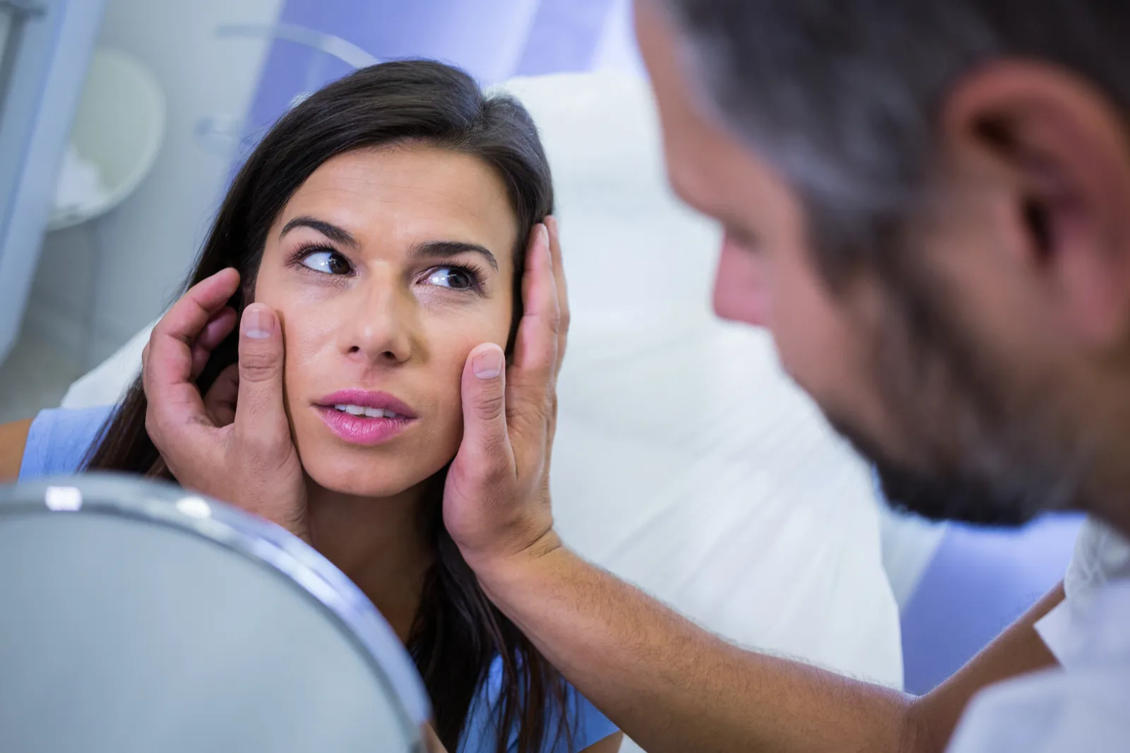 Doctor checks a patient's facial skin after treatment