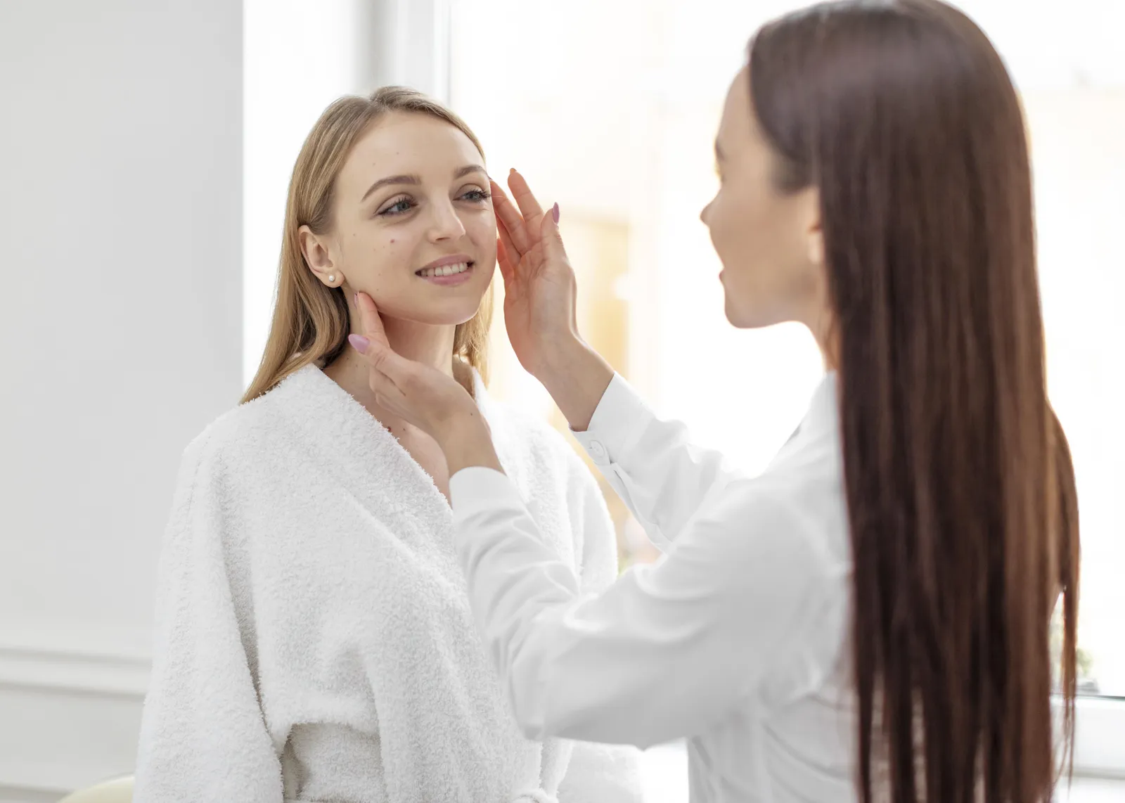 Aesthetic specialist assesses a client's face before treatment