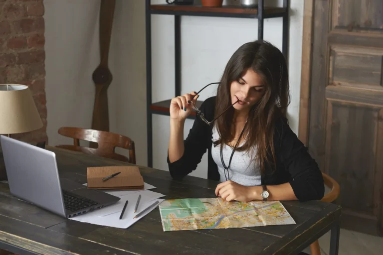 Woman plans a trip with a map and a laptop