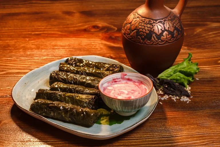 Armenian dolma served with yoghurt-mint sauce on a wooden table
